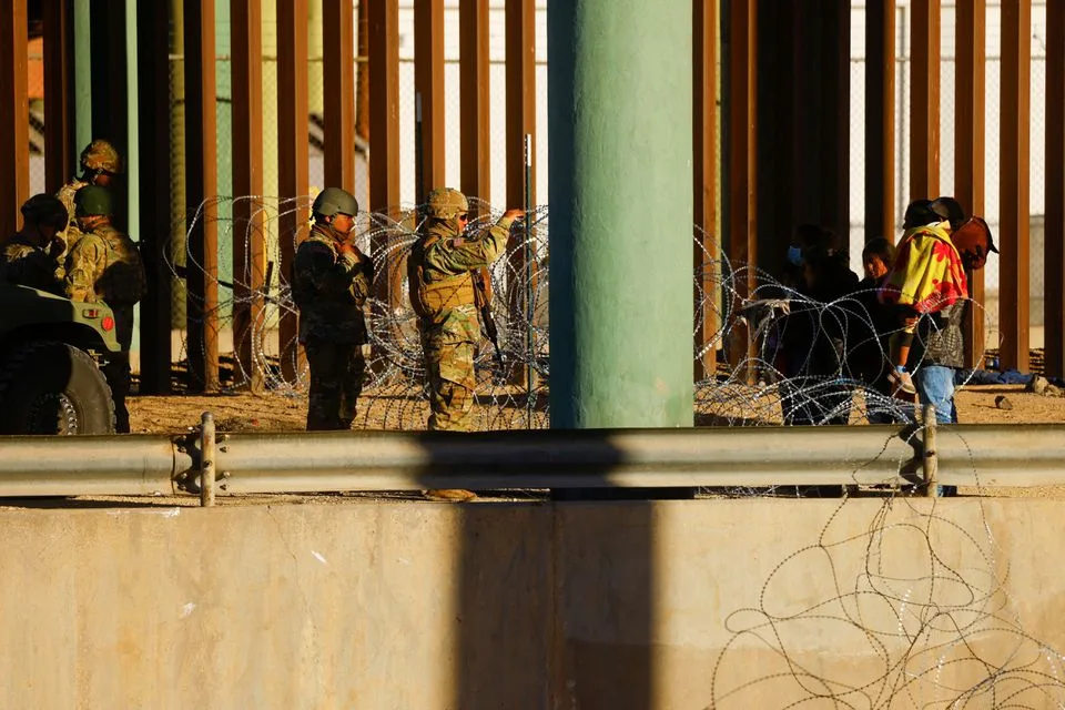 [1/6] Members of the Texas National Guard stand guard on the banks of the Rio Bravo river, the border between the United States and Mexico, with the purpose of reinforcing border security and inhibiting the crossing of migrants to the United States, seen from Ciudad Juarez, Mexico, December 27, 2022. REUTERS/Jose Luis Gonzalez