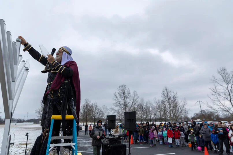Rabbi Areyah Kaltmann of Columbus, Ohio, lights the menorah in Bevelhymer Park on Dec. 18, 2022. Kaltmann is dressed as Judah Maccabee, the hero of the Hanukkah story. Photo by Harry Acosta Photography